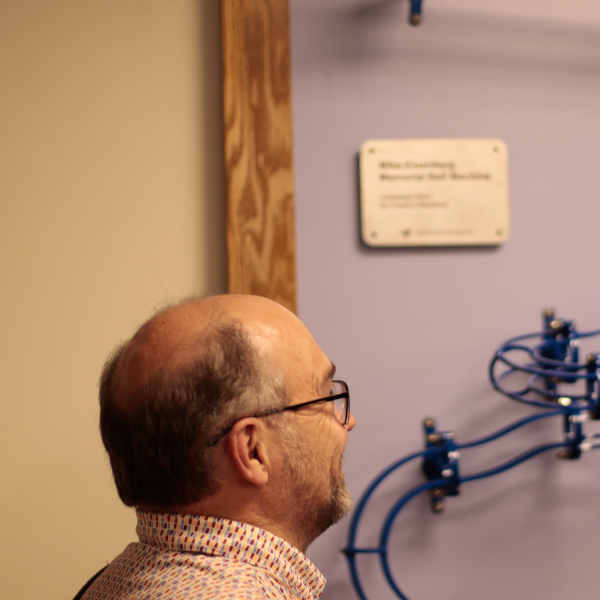 Ken Anderson looks at the ball machine created in honor of Mike Eisenberg
