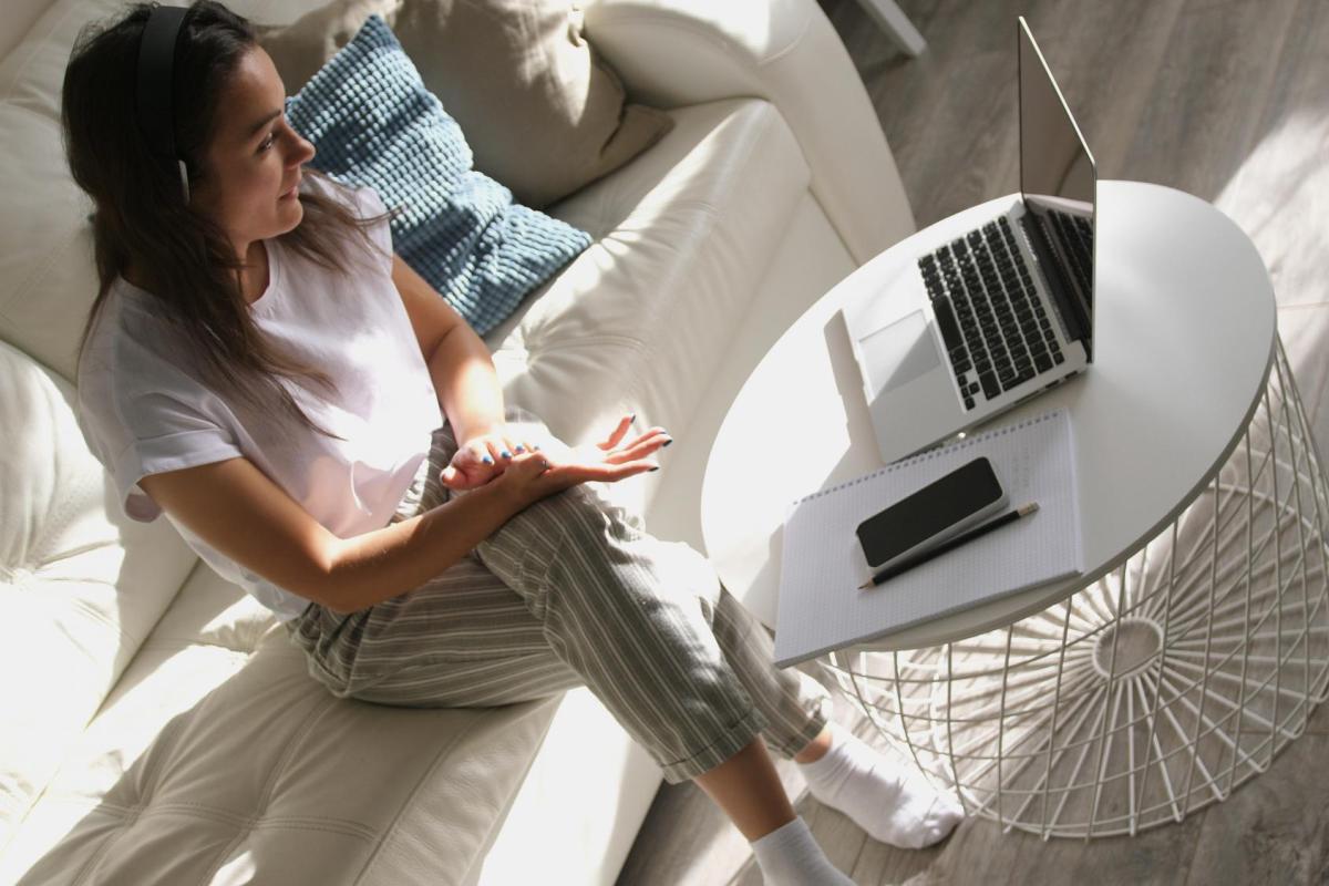 A distance learning student on her couch with her laptop