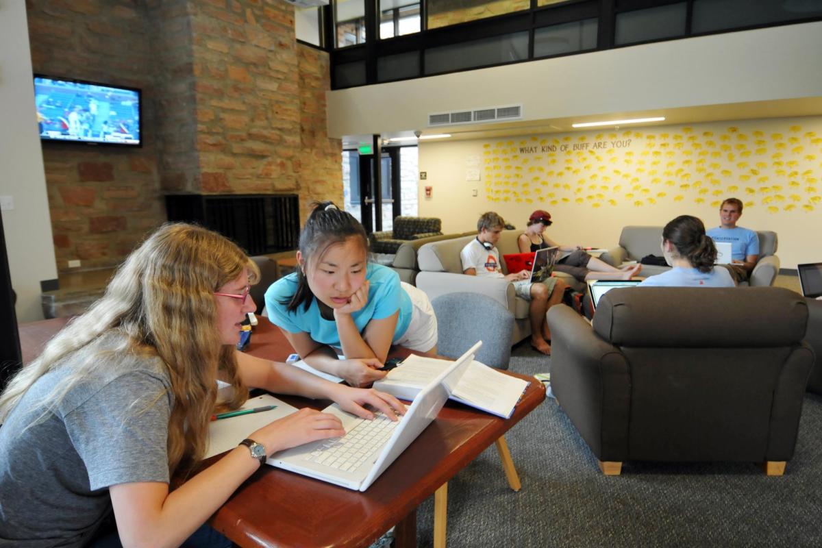 Two students work on a project in the common area of Andrews Hall