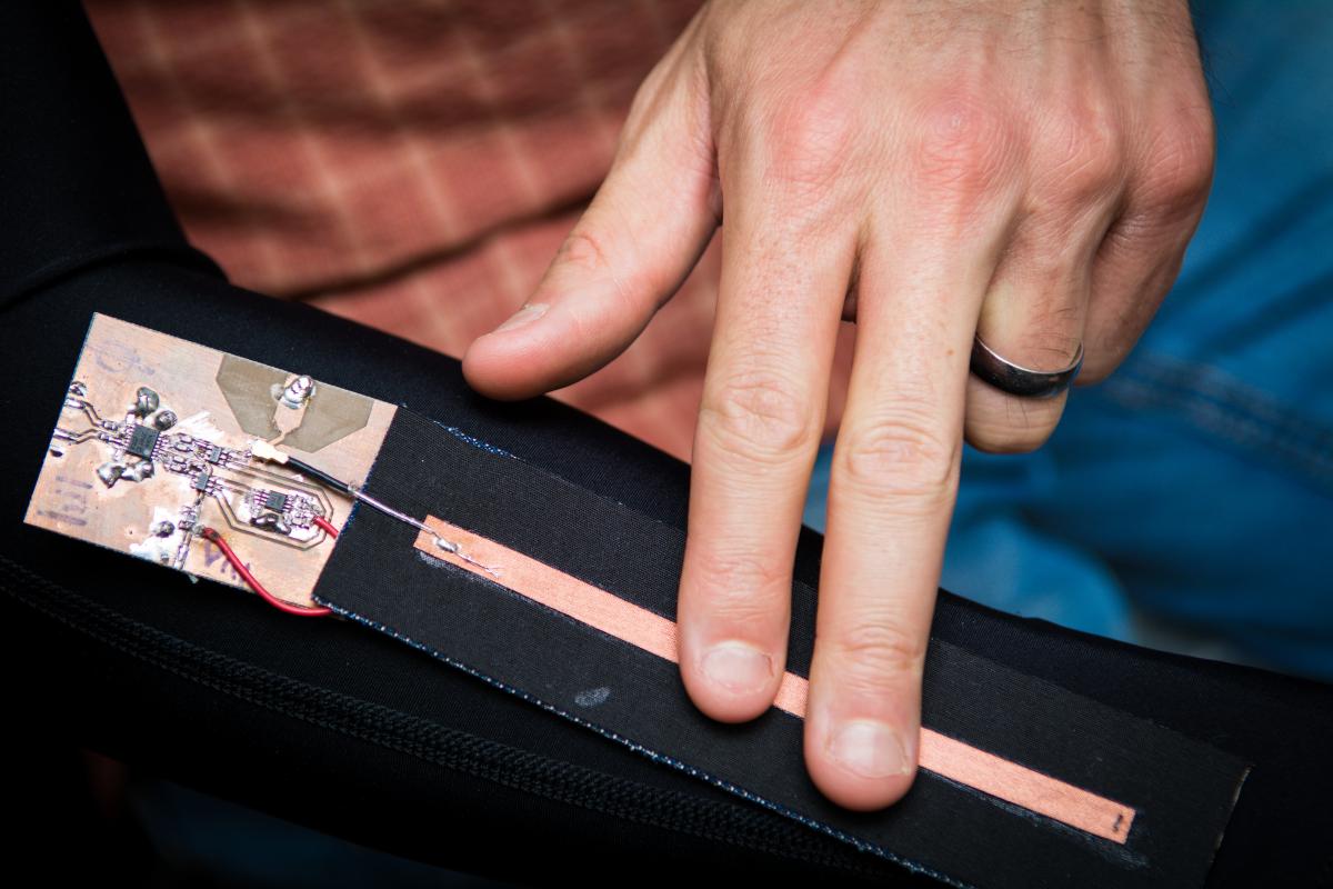 A graduate student demonstrates a wearable technology device. 