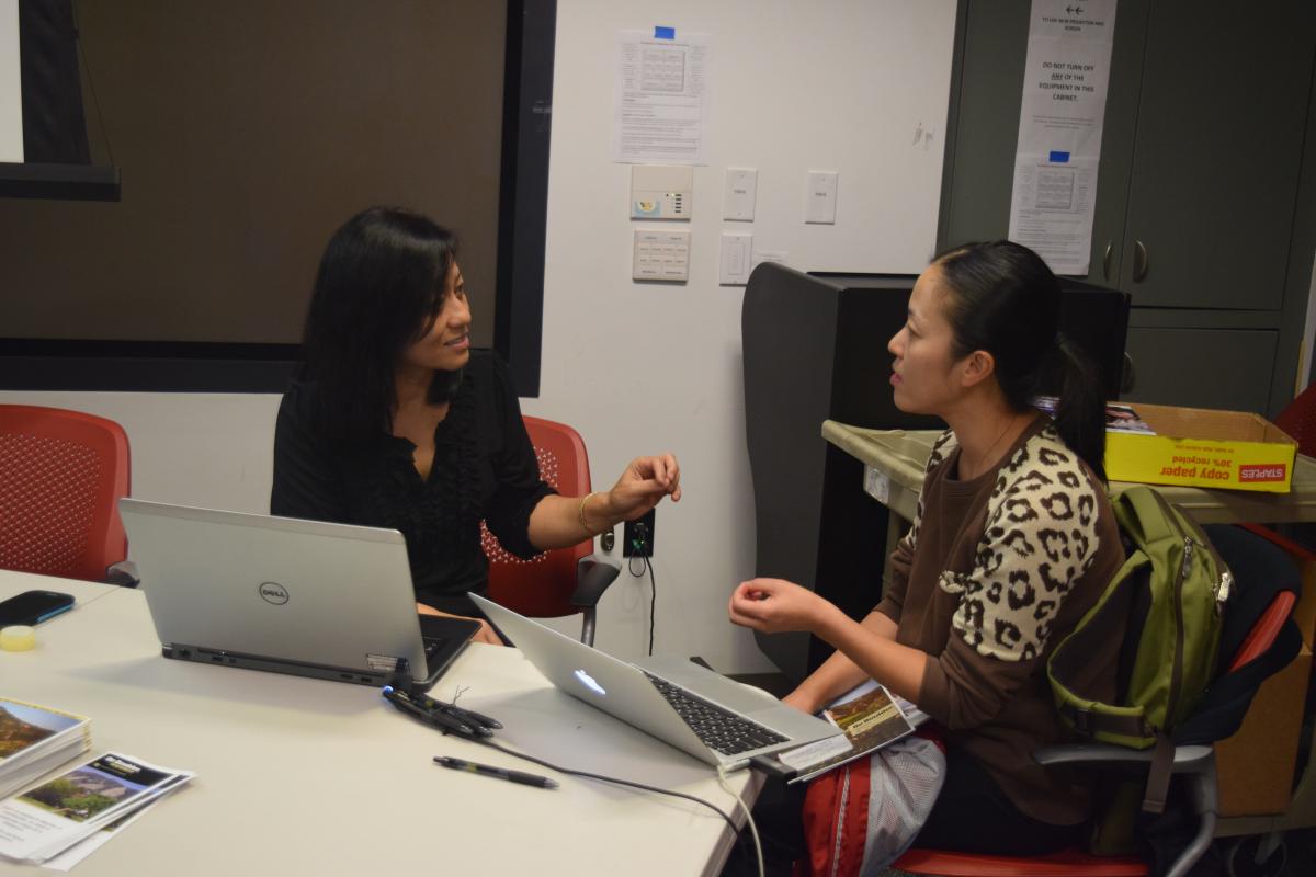 Advisor Rajshree Shrestha speaks with a prospective graduate student.