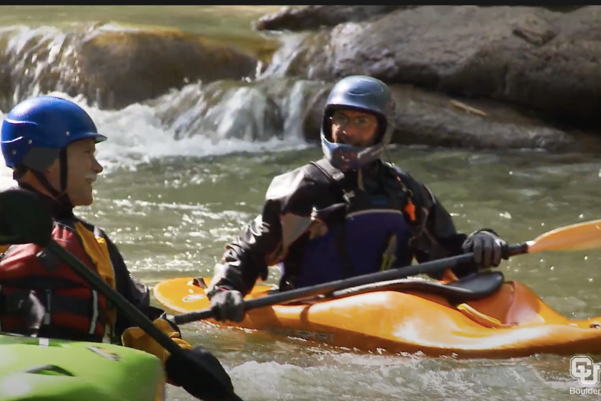 Two men in Kayaks paddle on a stream
