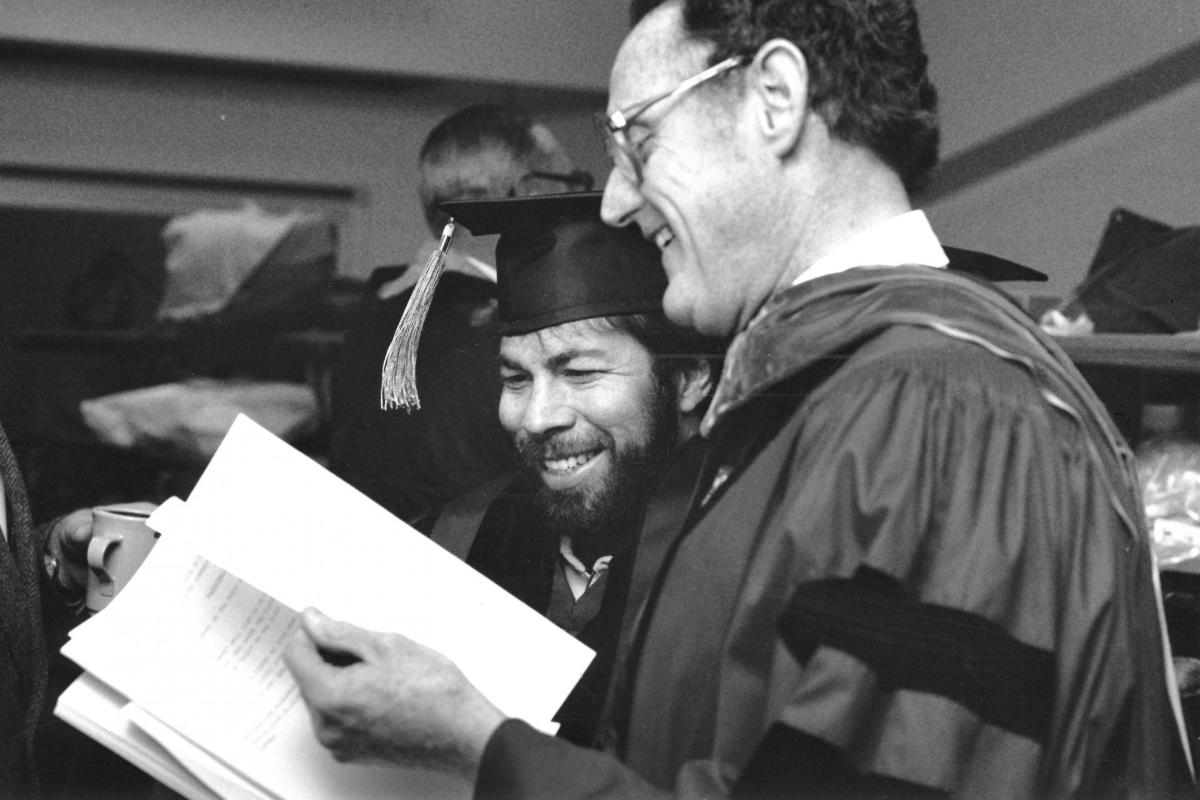 Steve Wozniak looks over the graduation program with engineering Dean Richard Seabass.