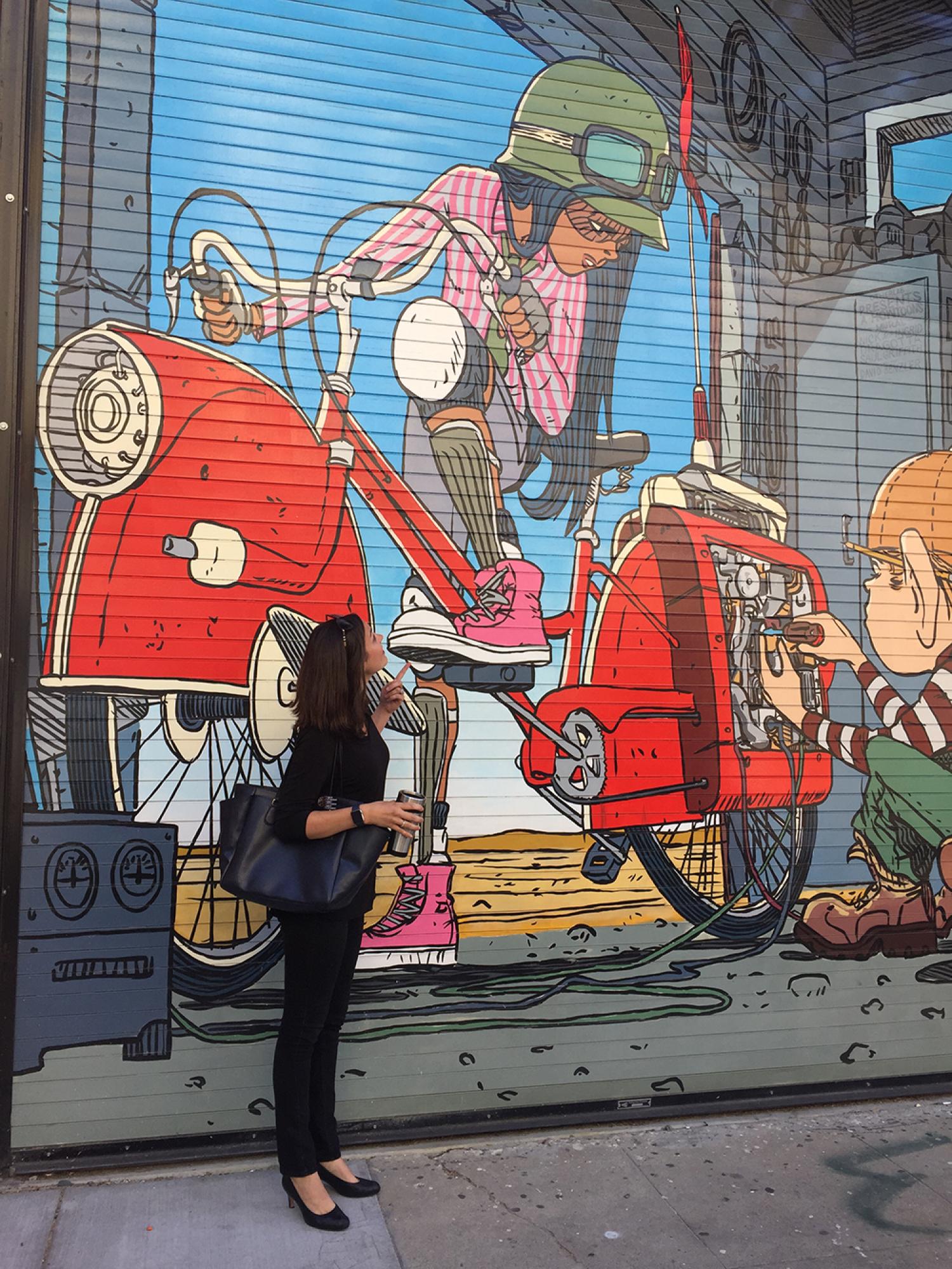 Kelly admires a mural on a building