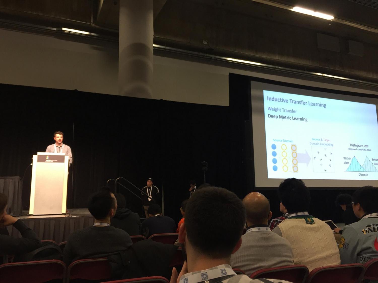 Tyler Scott on stage for his paper presentation during NeurIPS.