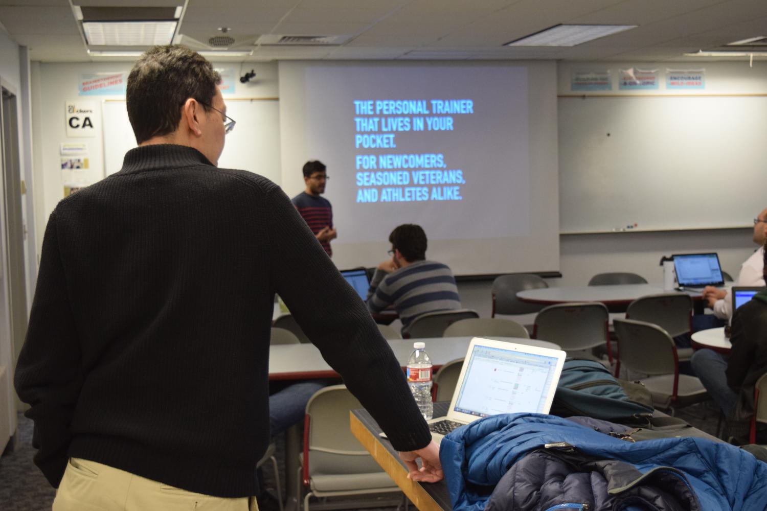 Rick Han looks on as his students practice their pitches during a class session