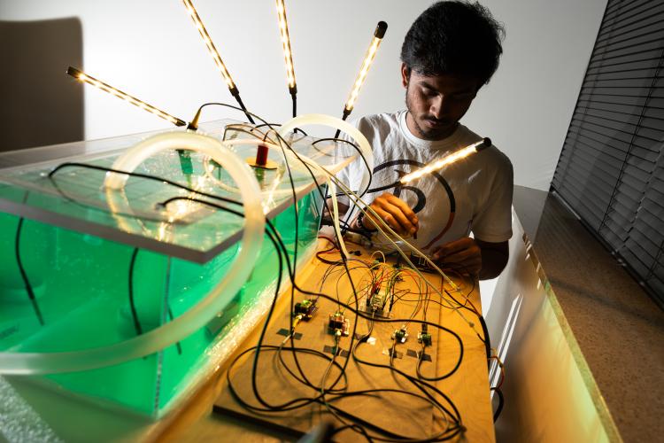 Sudarshan Sridhar with the electronics of the automated algae growth system