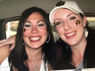 Kelly and a friend with CU Buffs stickers on their faces during their time at CU