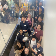 Computer science alumni in a stairwell with clipboards