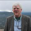 Clayton Lewis stands in front of foggy mountains