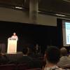 Tyler Scott on stage for his paper presentation during NeurIPS.