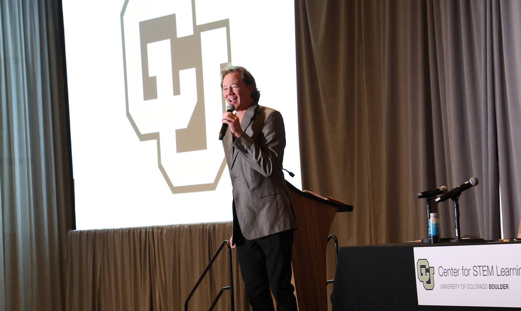 CSL Co-Director Brad McClain giving welcome speech in front of CU and CSL Logos