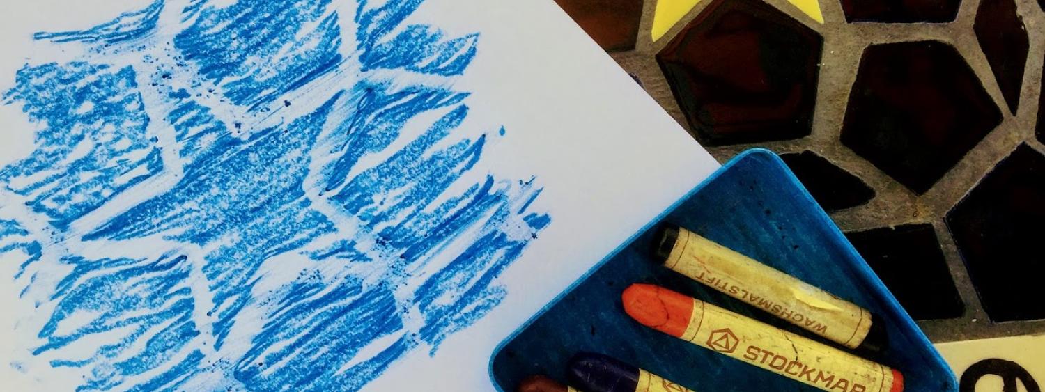Crayons and a blue crayon rubbing of a star