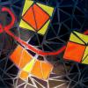 Mosaic Tiles, black background. showing yellow and orange triangles and squares , with red ribbon running thru