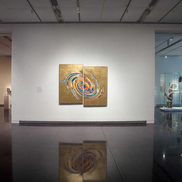 Installation view of diptych painting, gold with multi-color swirls