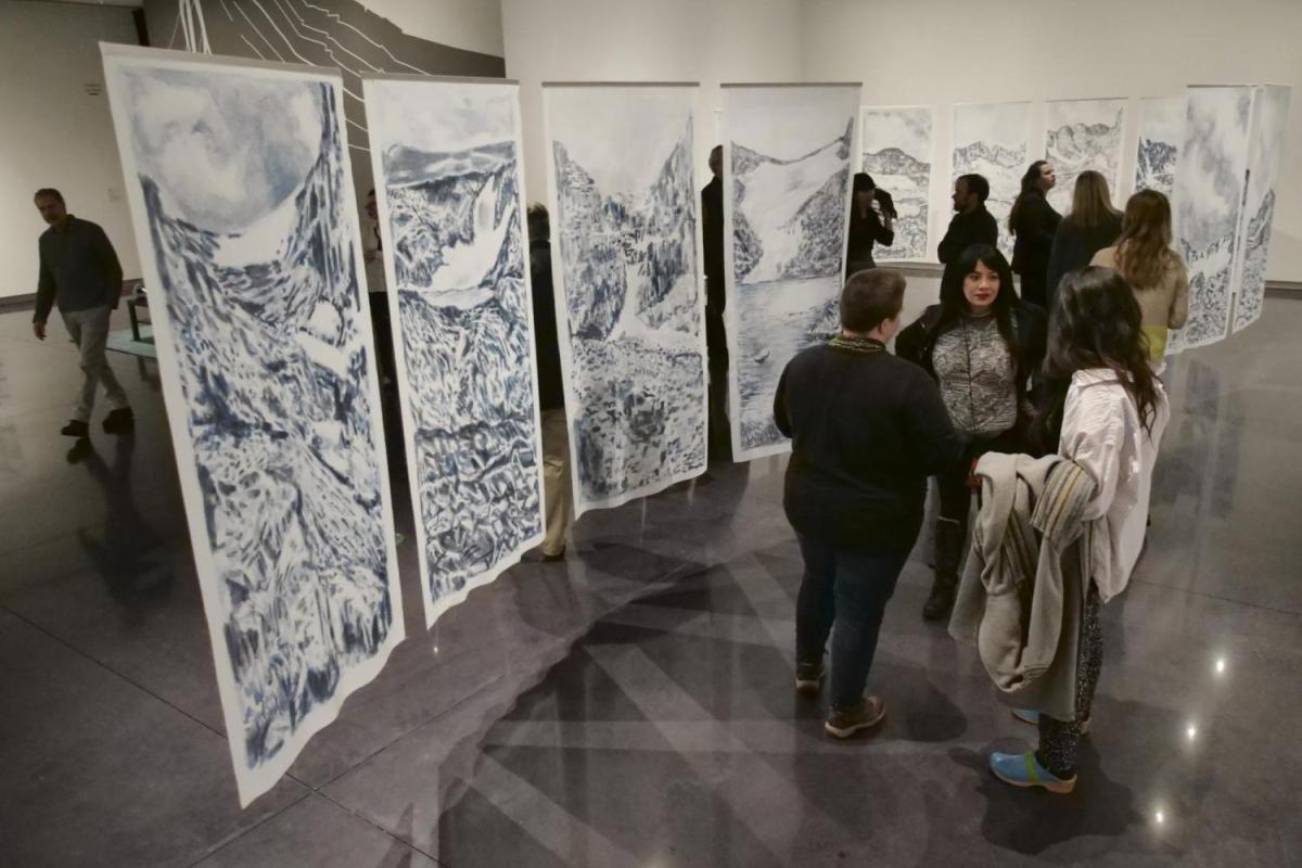 A group of female students stand in a gallery