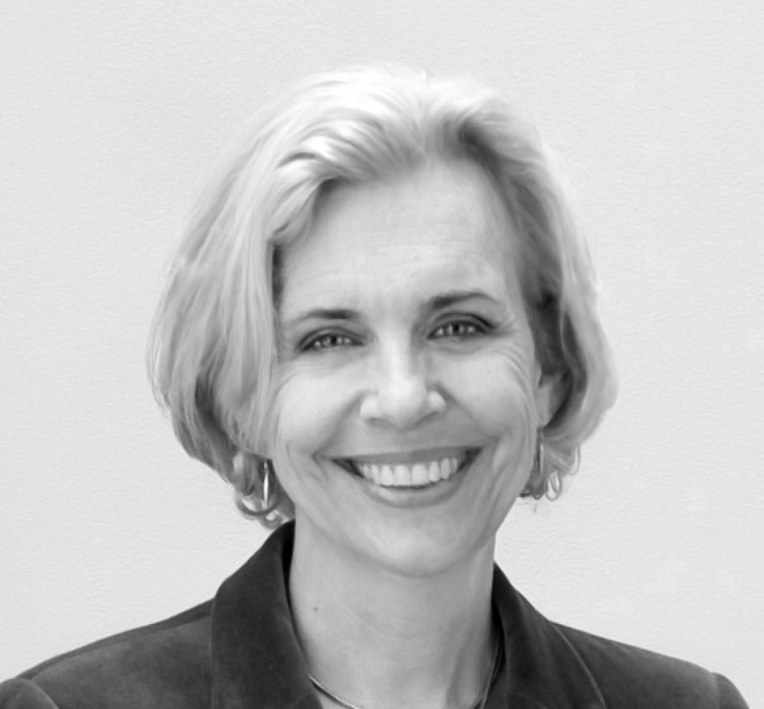A black and white headshot of Susan Tallman. She is white, with short, light hair and is smiling.