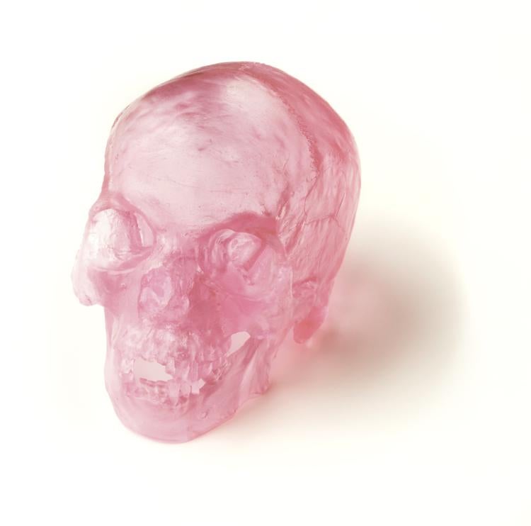 A skull cast in pink glass