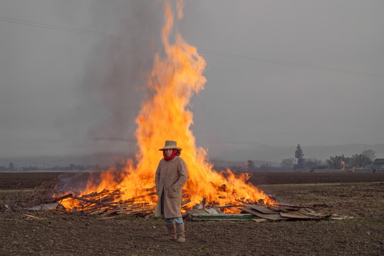 a woman standing in front of a fire