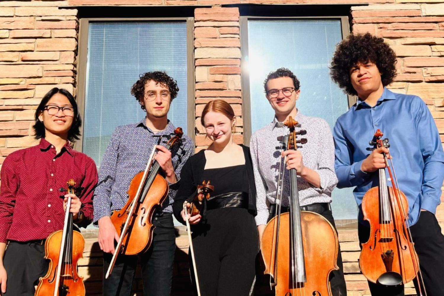 The Gardetto Quintet standing in front of a building on the CU Boulder campus while holding their string instruments.
