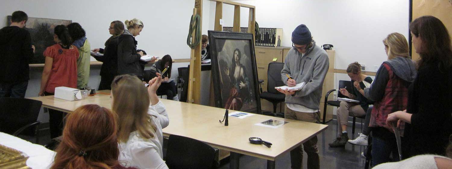 Students study a painting on an A-frame rack