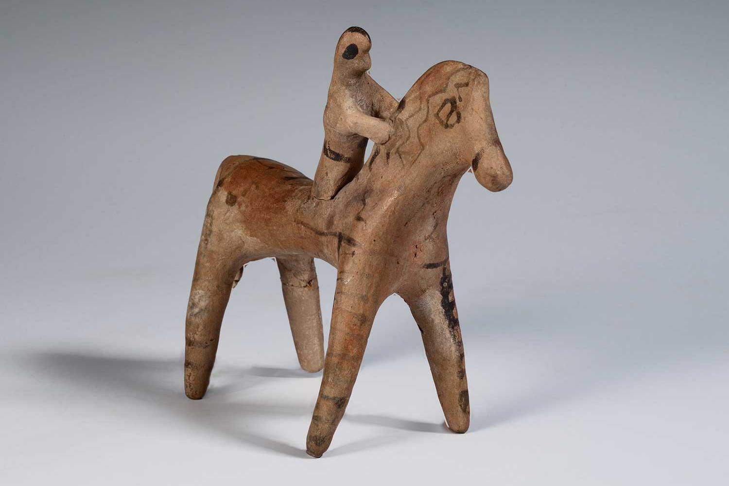 Crude tan clay figurine of man on horseback