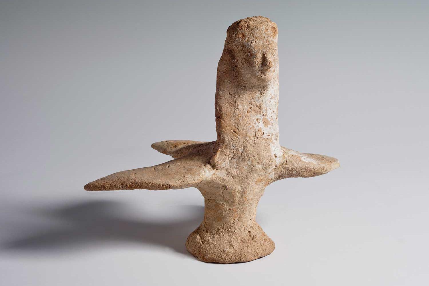 Ceramic figurine of a bird featuring a woman’s face