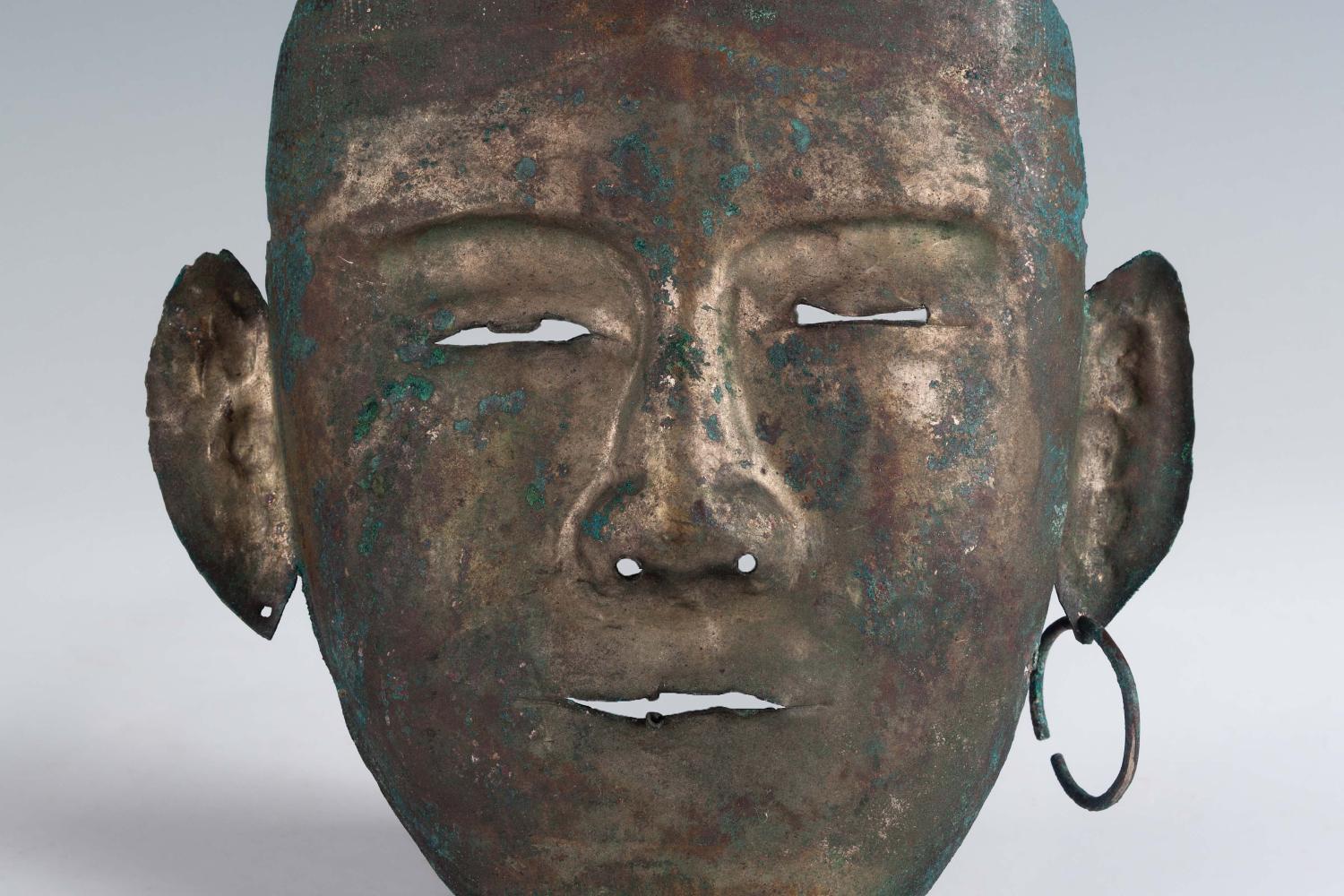 Bronze death mask with hoop earring