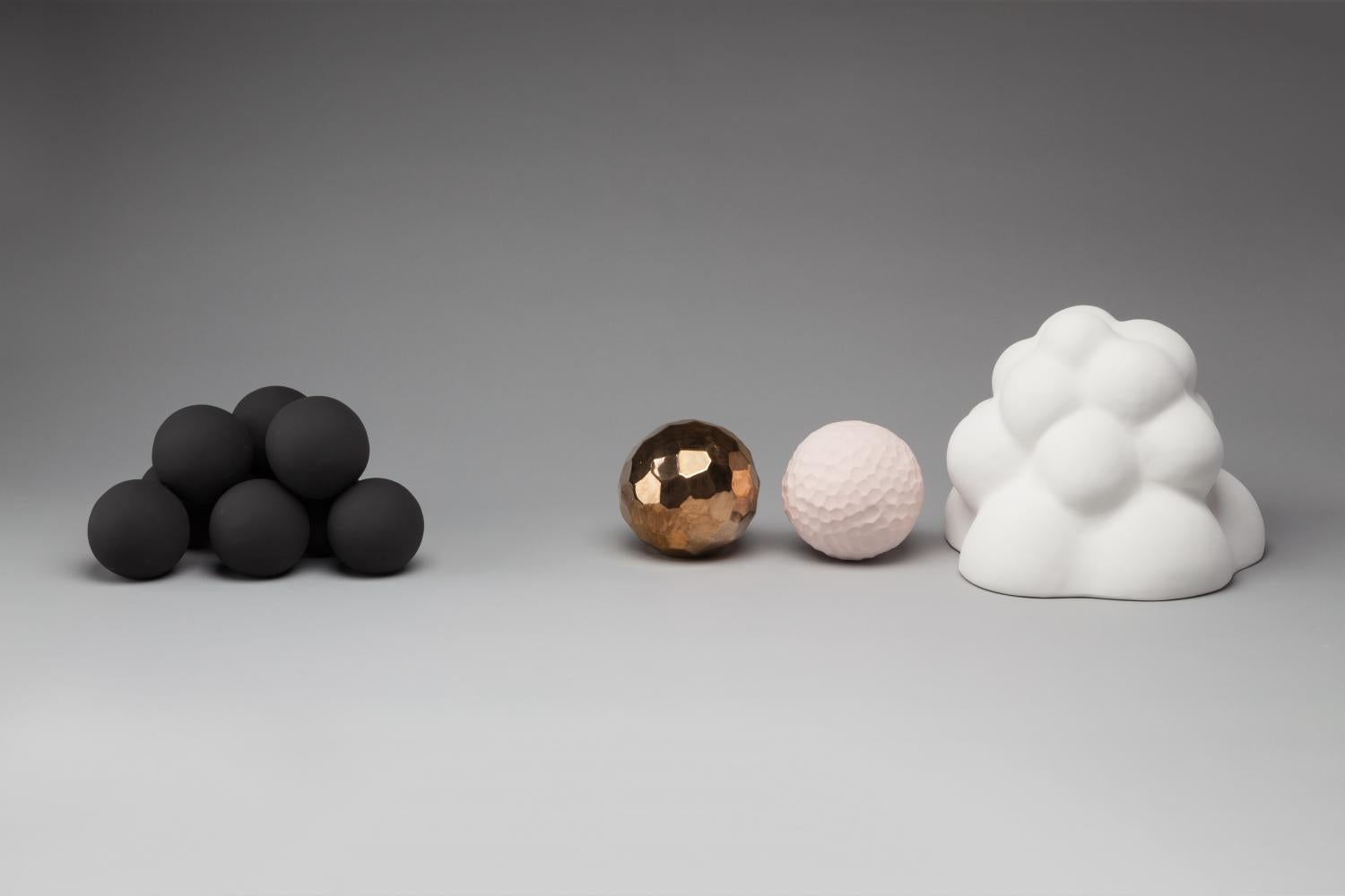 four ceramic forms on a grey background