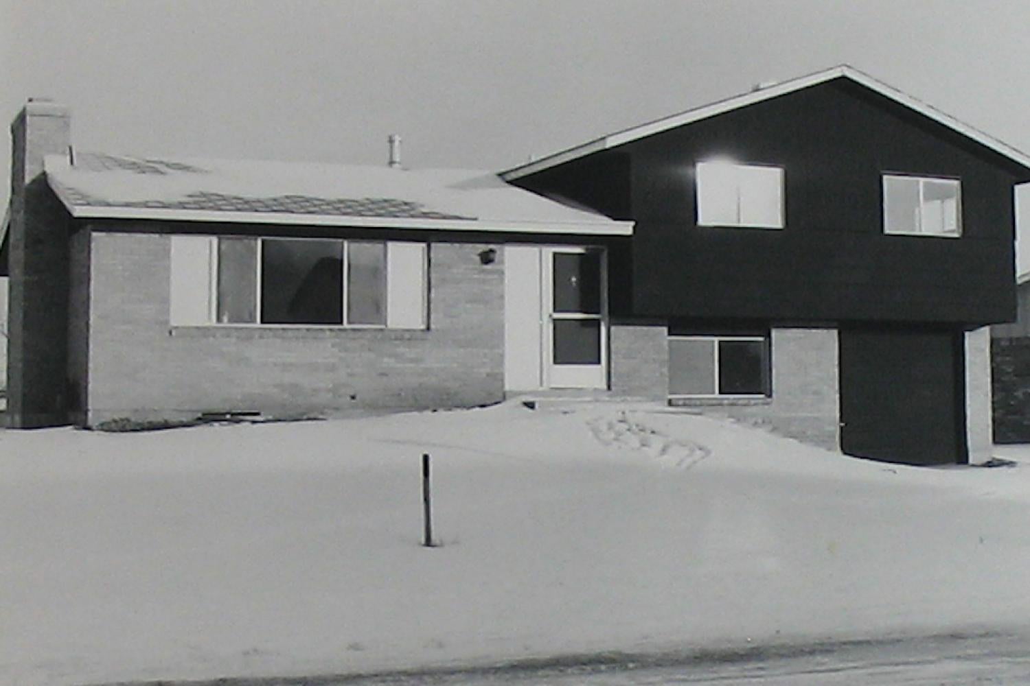 black and white photograph of a split level suburban home