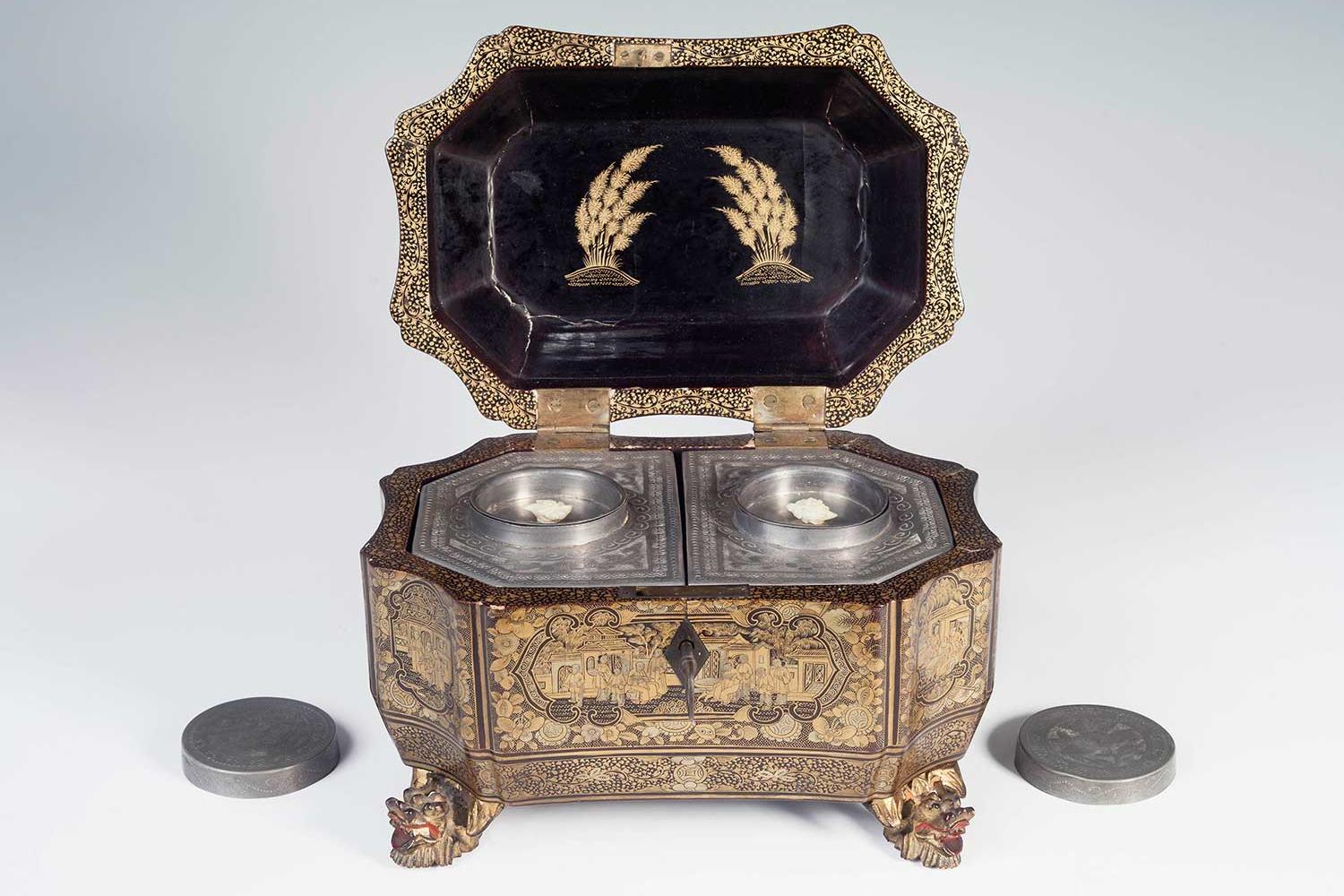 a sliver box with lid lifted and circular pieces removed and sitting beside the box.