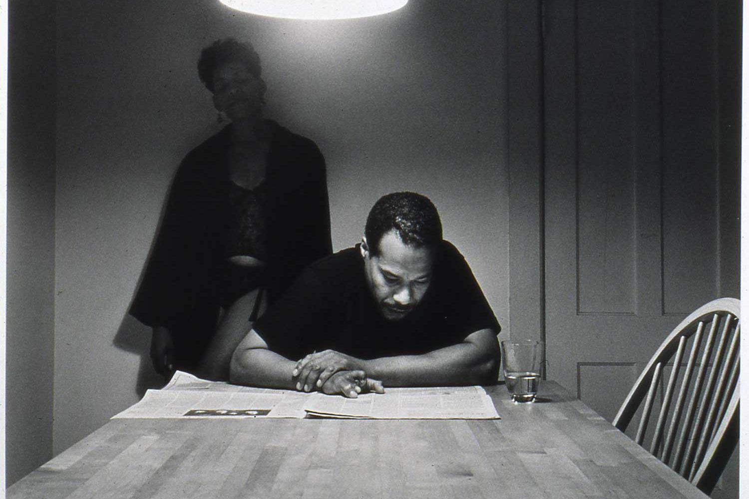 two african american figures, a man and a woman, at a kitchen table
