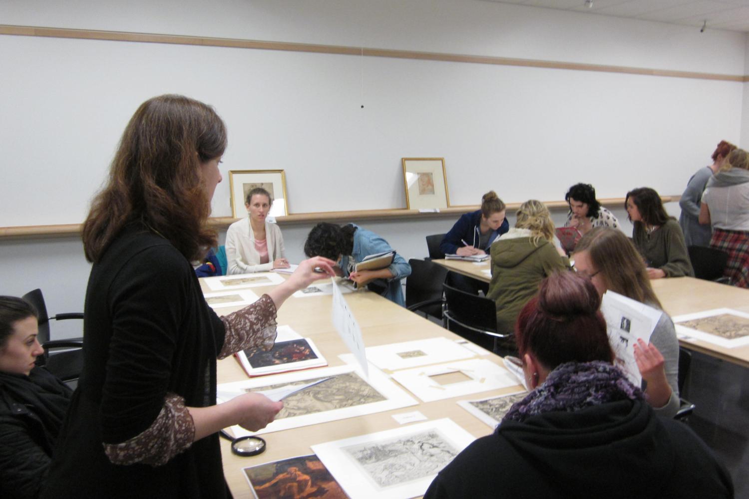 A female professor speaks to students.