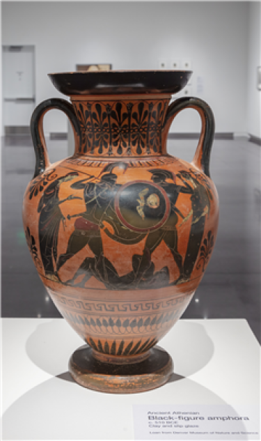 An amphora with black figures on either side. The vessel is mostly reddish and there is a variety of black decoration throughout.