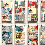 Many rectangular pages of collaged paper with colorful houses, other designs and text clipped to a metal line and hanging in front of a white wall.