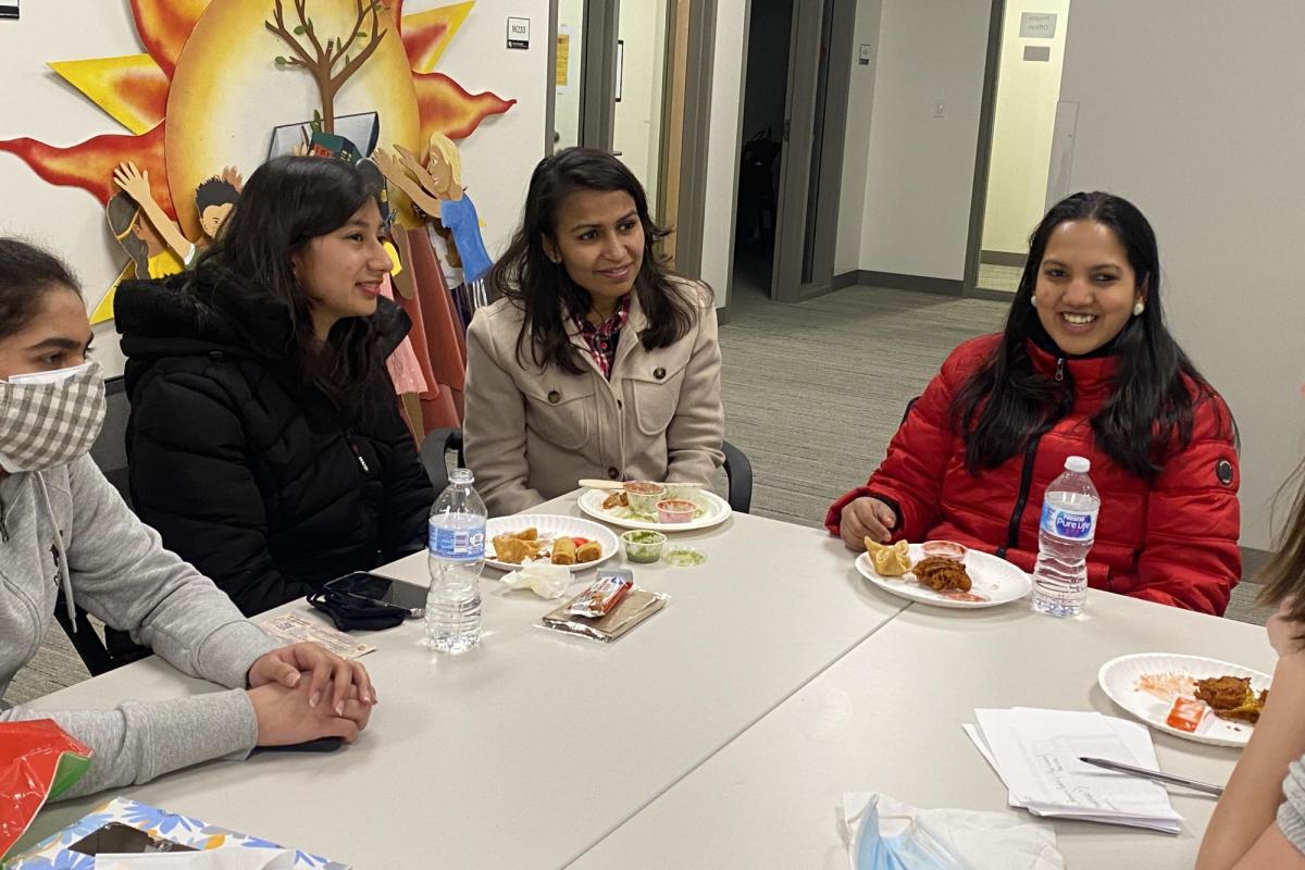 students talk and smile together at an AAPI community gathering