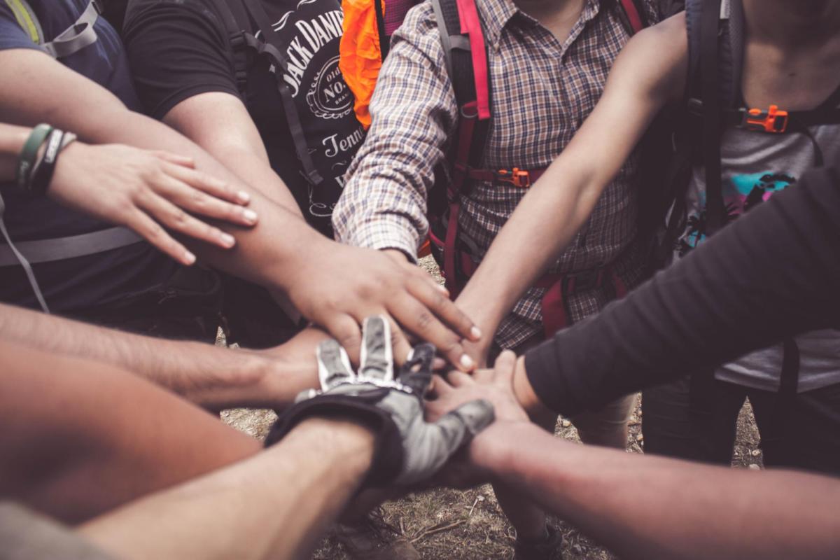 A group of people with their hands together in a circle.