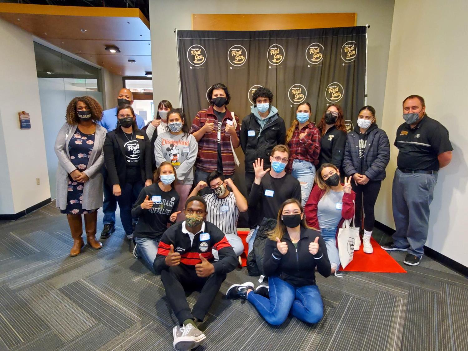 a group of first-gen students, staff and faculty pose for a photo together at a social event
