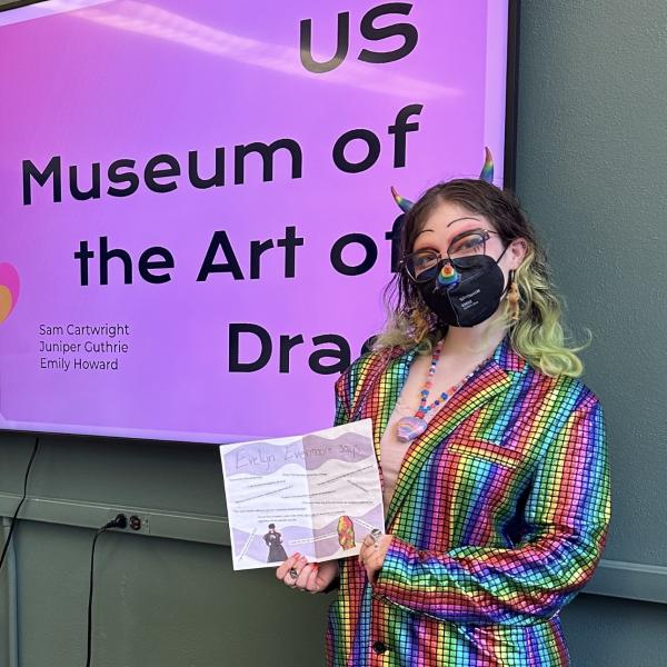 Emily Howard in rainbow suit in front of presentation screen
