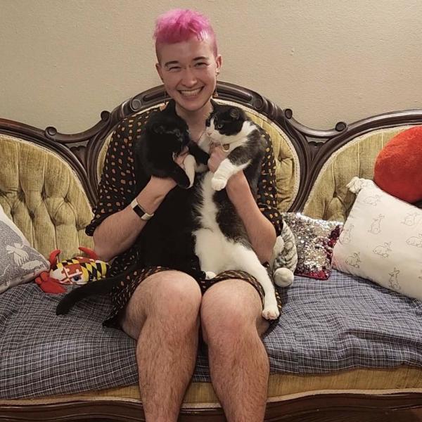 Juniper guthrie on couch holding two cats