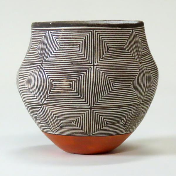 clay pot with black and white geometric striped patterns and orange base