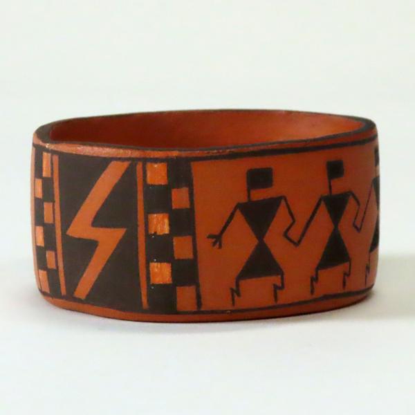shallow clay bowl with black and orange paint and figures