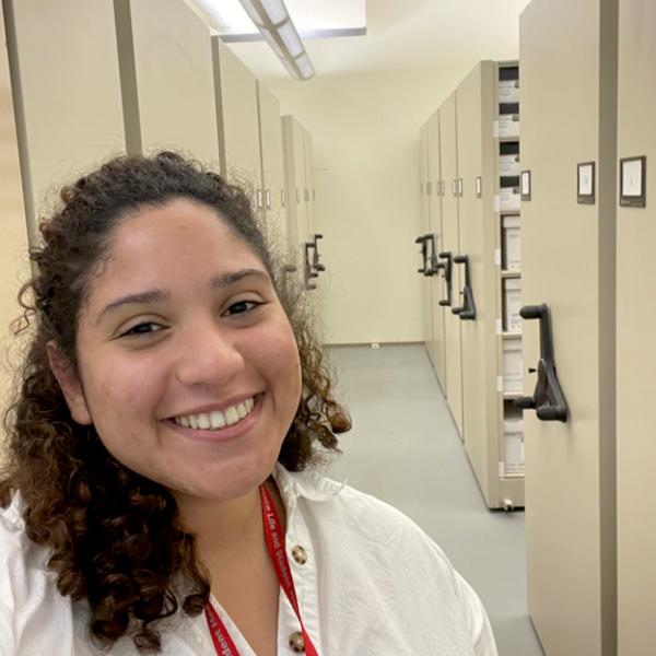 headshot of woman smiling in front of collections cabinets