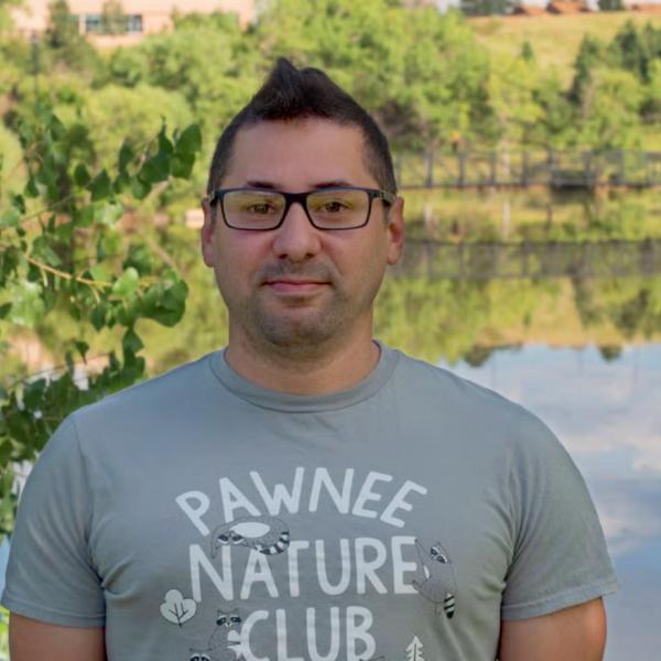 Headshot of man standing in front of lake