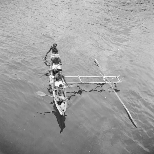 Four men in canoe in the middle of the sea