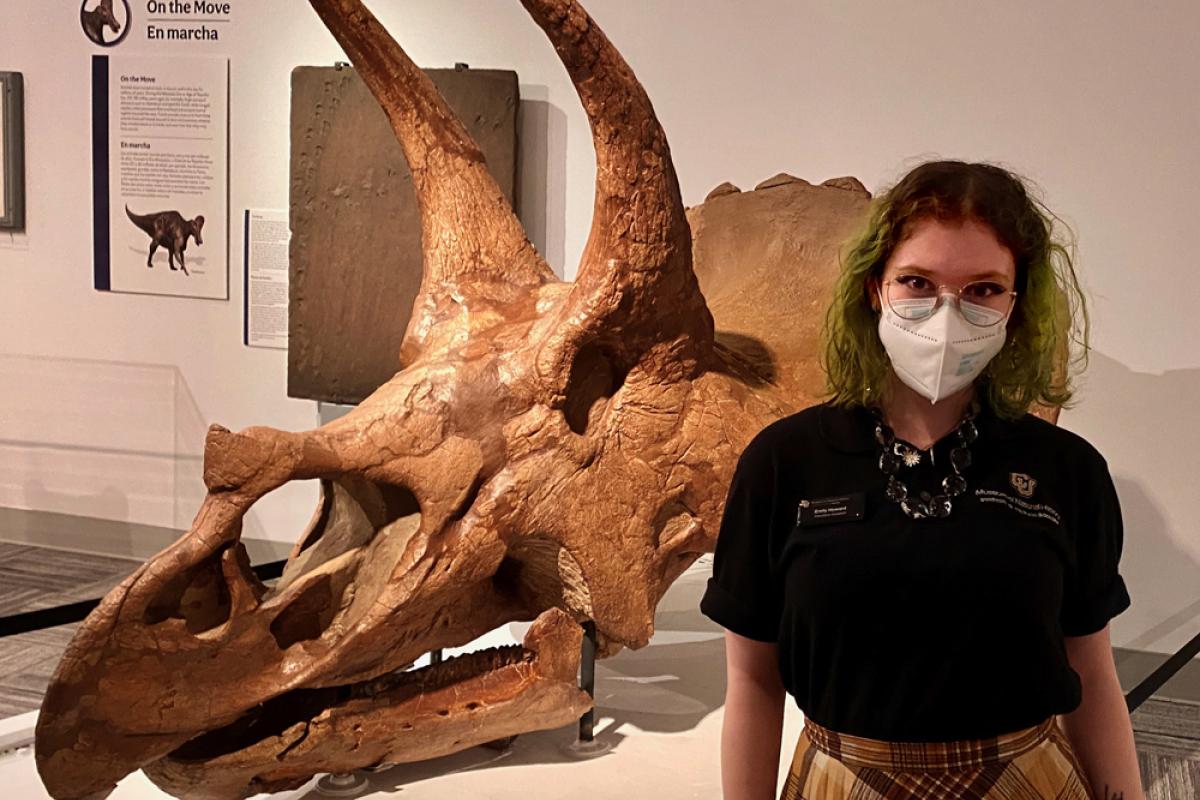 Emily Howard standing in front of triceratops skull in Paleontology Hall