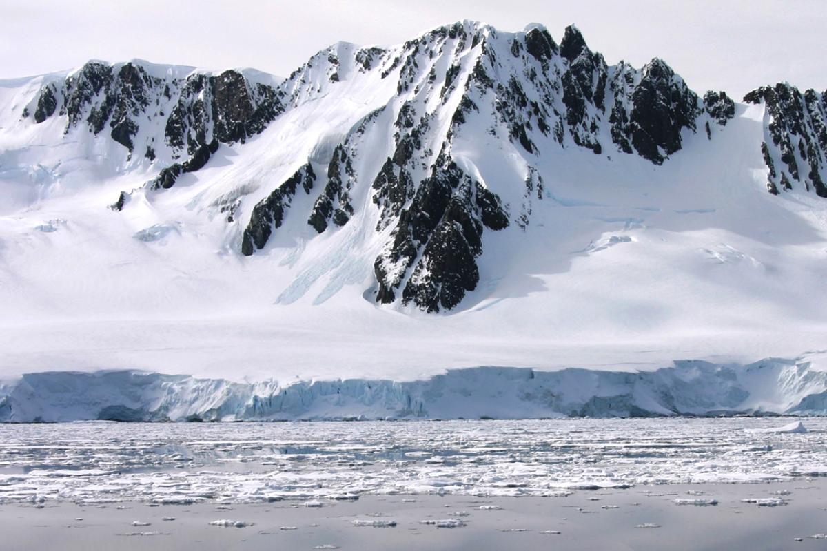 Mountains covered in snow sitting next to coast