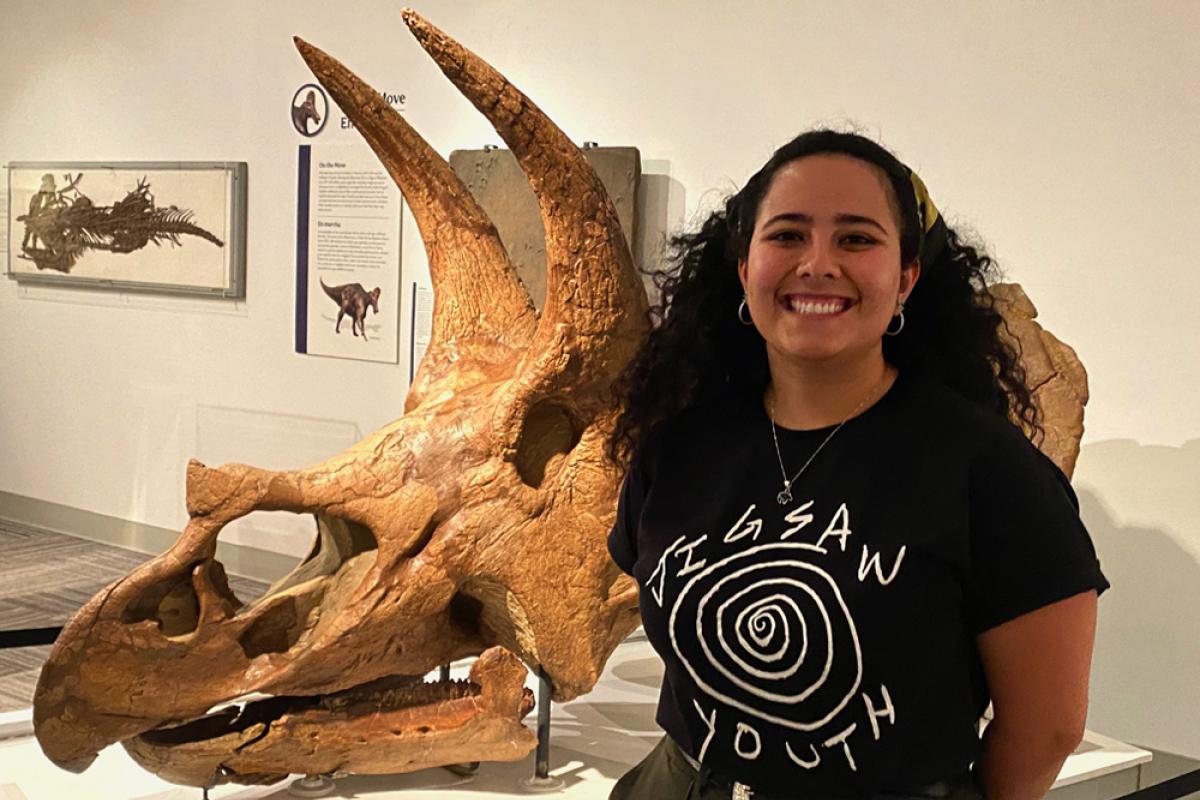 Hope Fox standing in front of triceratops skull in Paleontology Hall