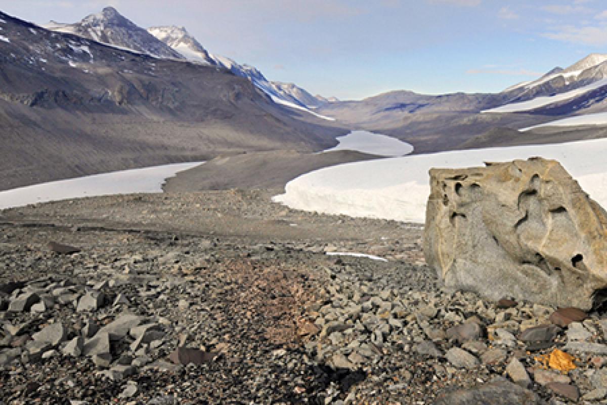 rocky soil with snow capped mountains in the distance