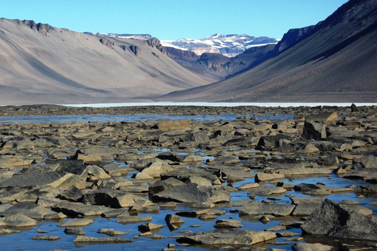 Blue rocky stream with dry mountains in the background